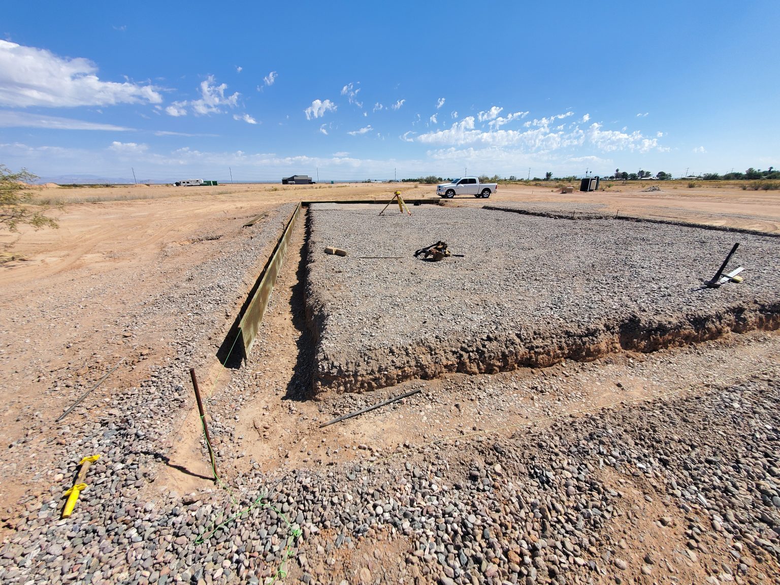 Construction site, desert view, dirt, blue skies, bright hot day.