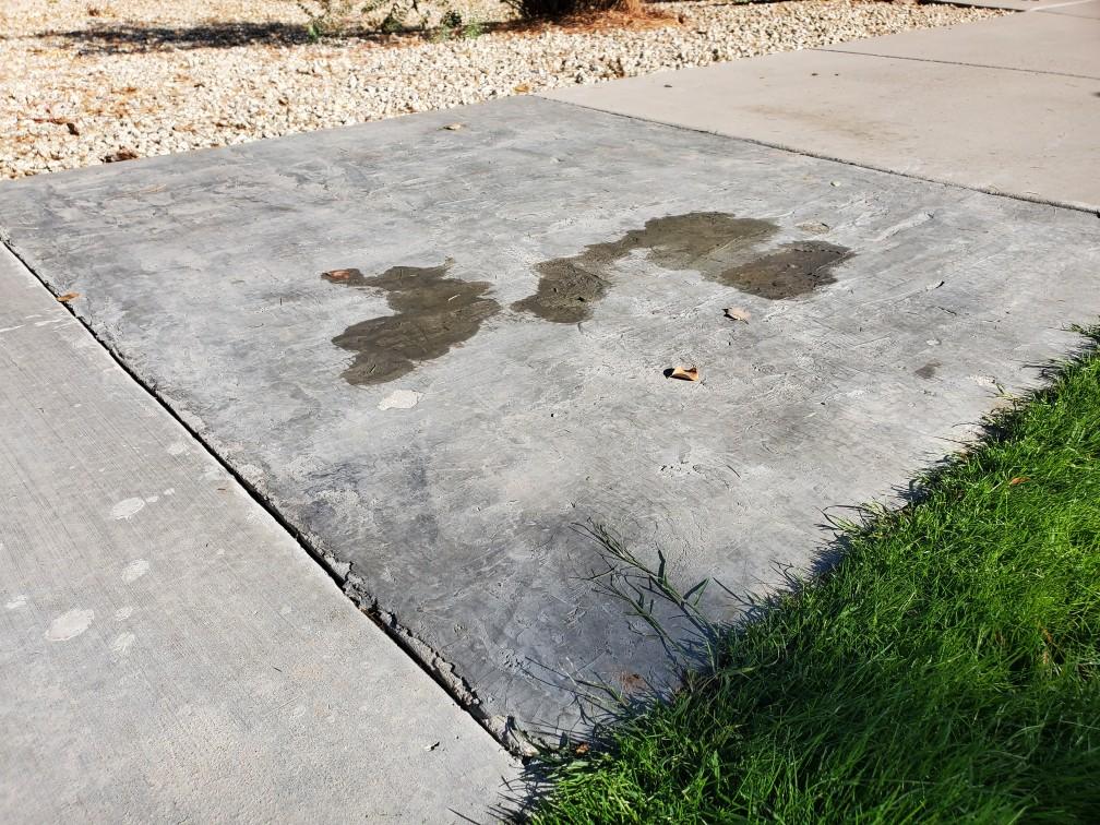 A section of concrete sidewalk that is chipped and damaged.