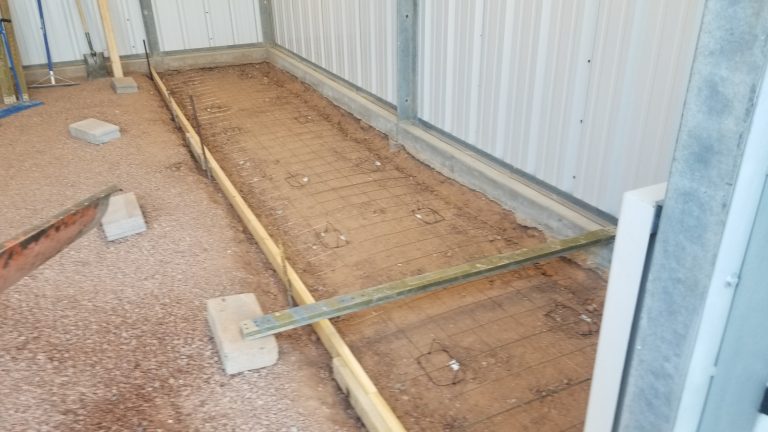 A formed up space ready for new concrete. Wire mesh covers the area.