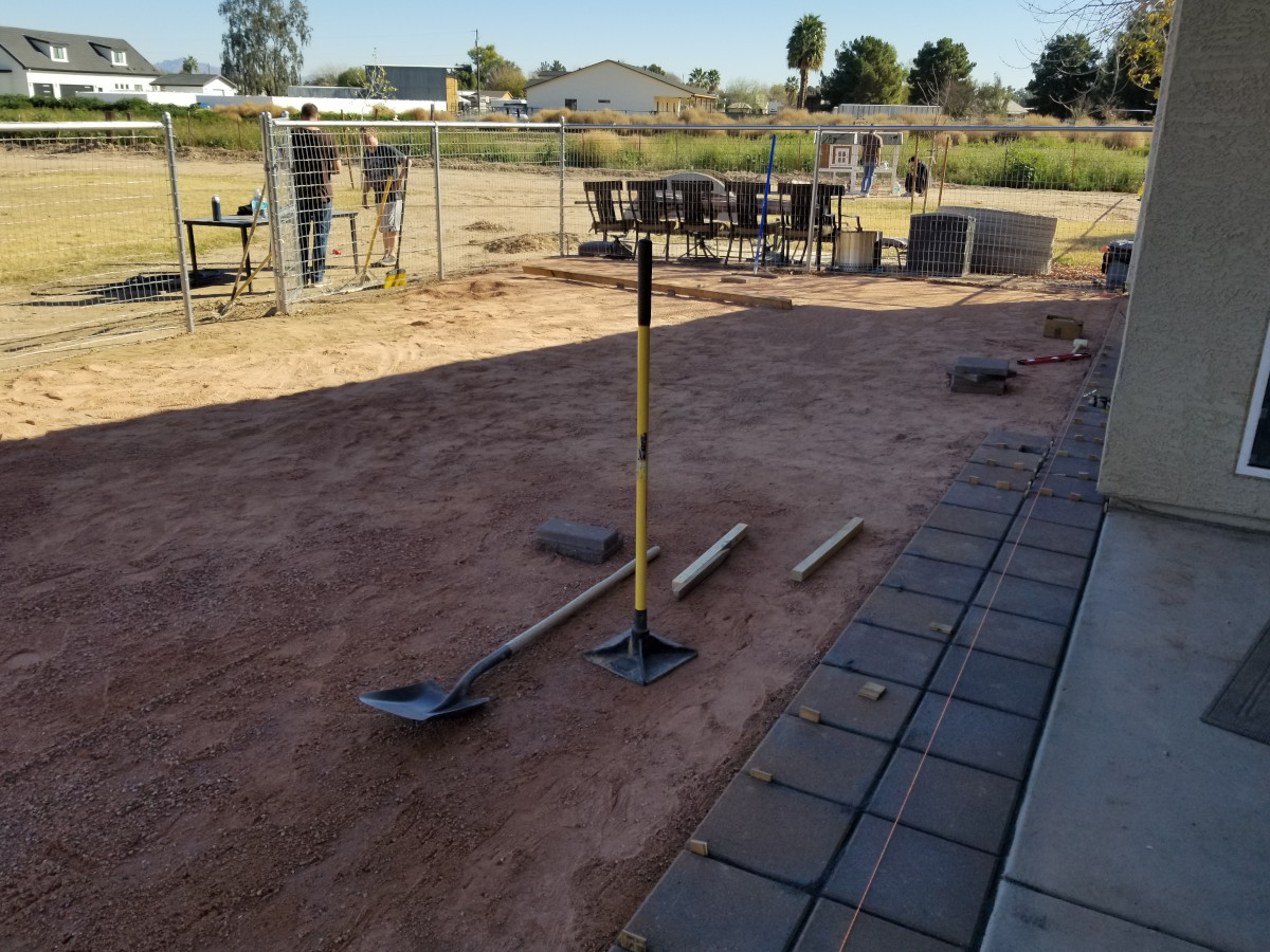 Beginning phase of laying pavers for a backyard patio in Gilbert, Arizona.