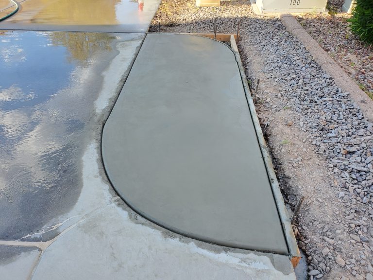 A newly poured concrete section on a driveway, still formed up and drying.