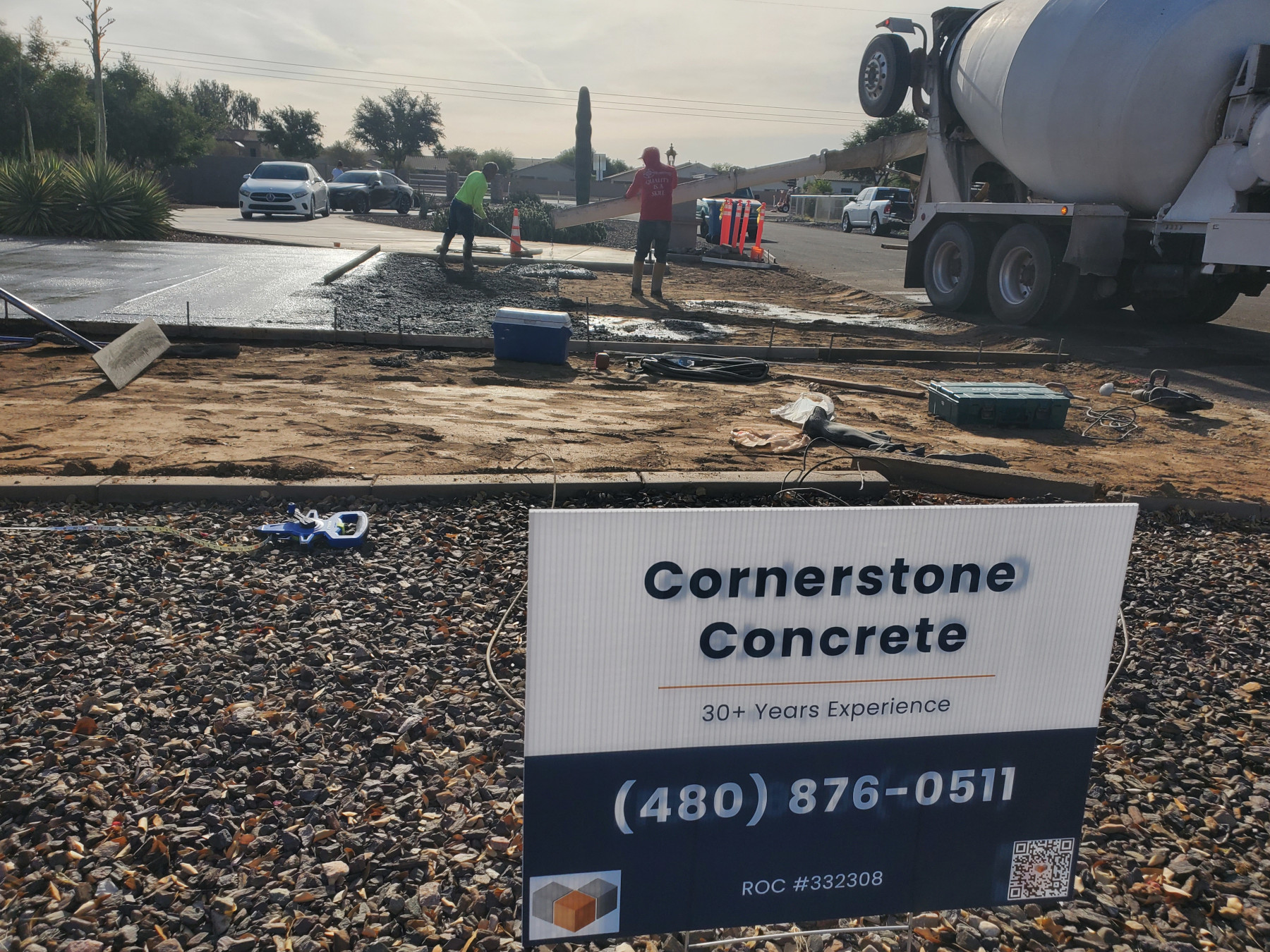 Cornerstone Concrete jobsite sign with active crew and concrete work in progress.