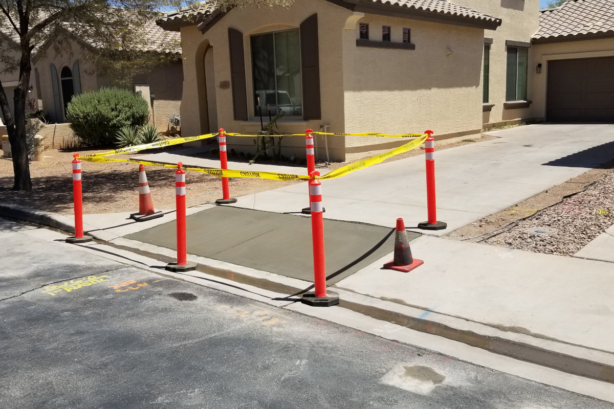 Freshly poured and finished concrete with caution tape and barriers