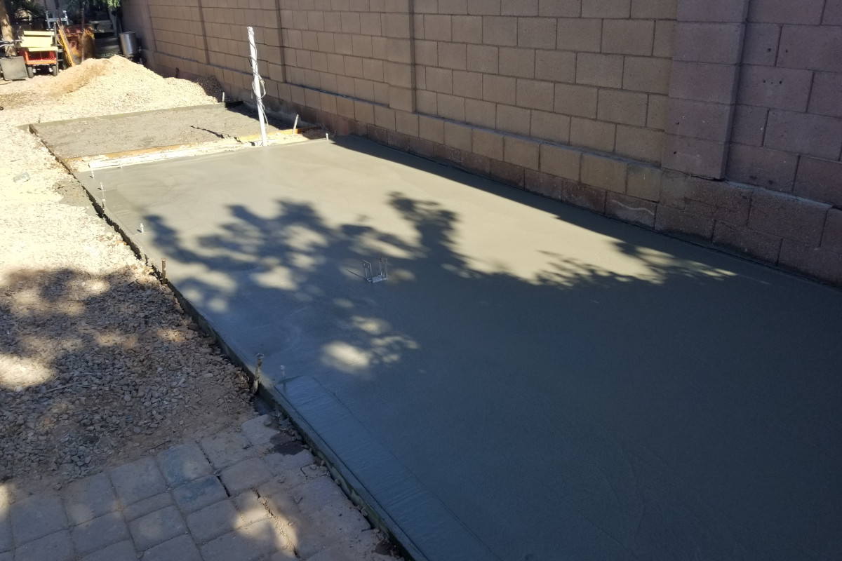 Freshly poured concrete shed pad and patio section in Chandler, Arizona.