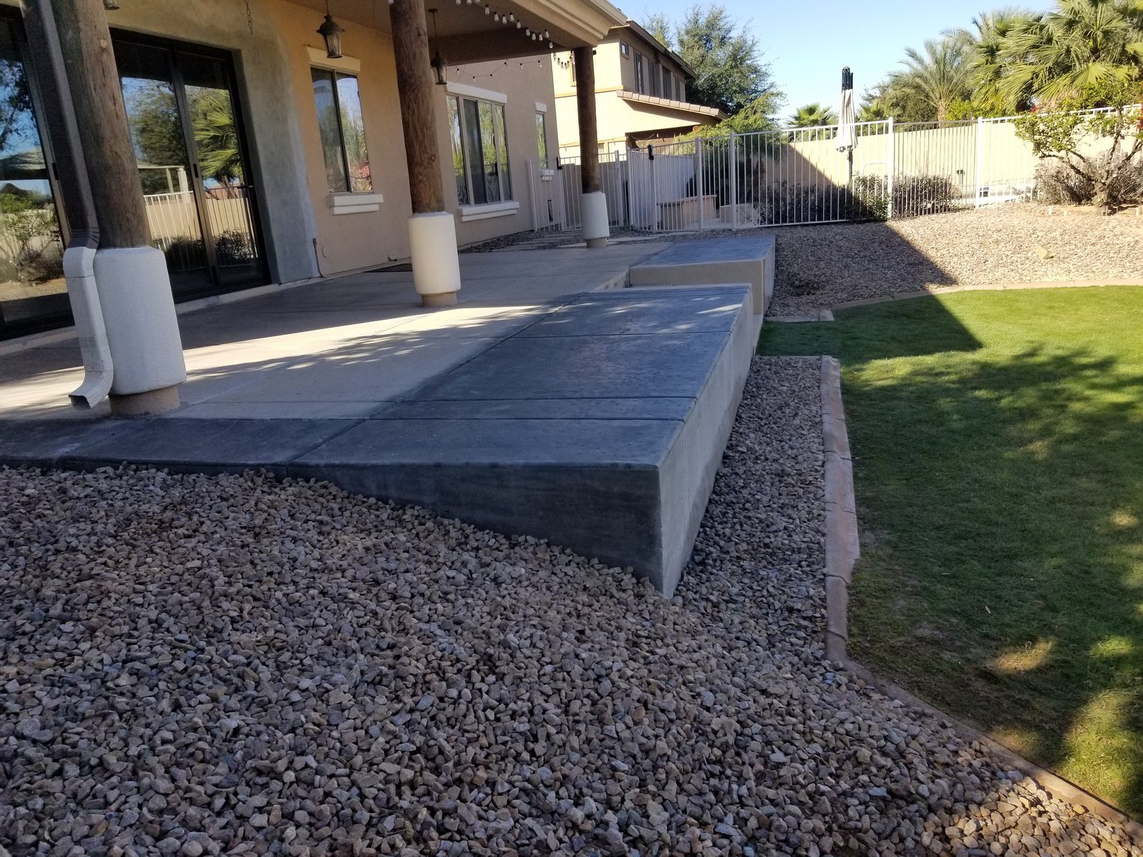 Finished raised patio and retaining wall viewed along the lawn edge