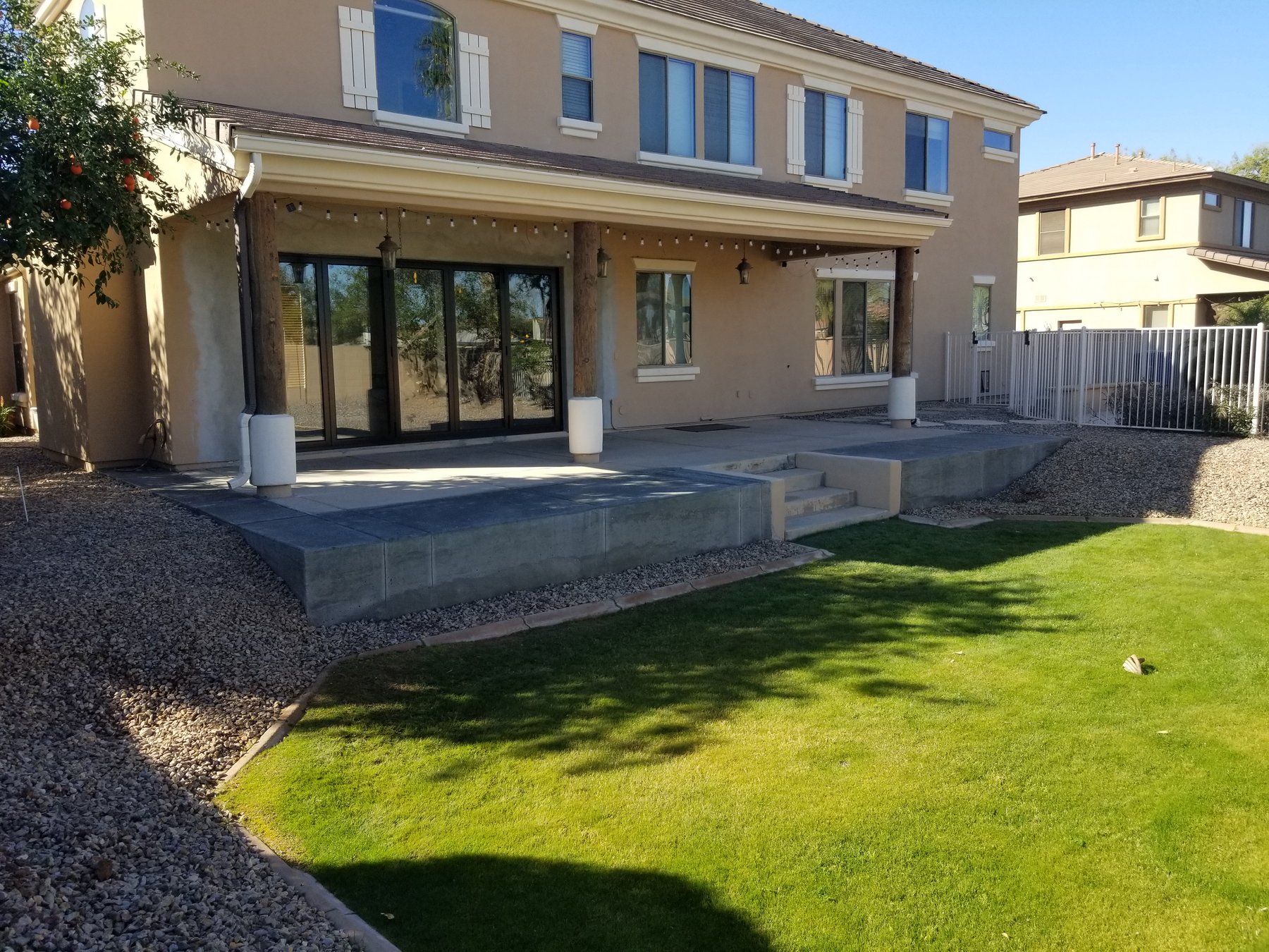 Finished raised concrete patio and retaining wall along the backyard of a Chandler home.