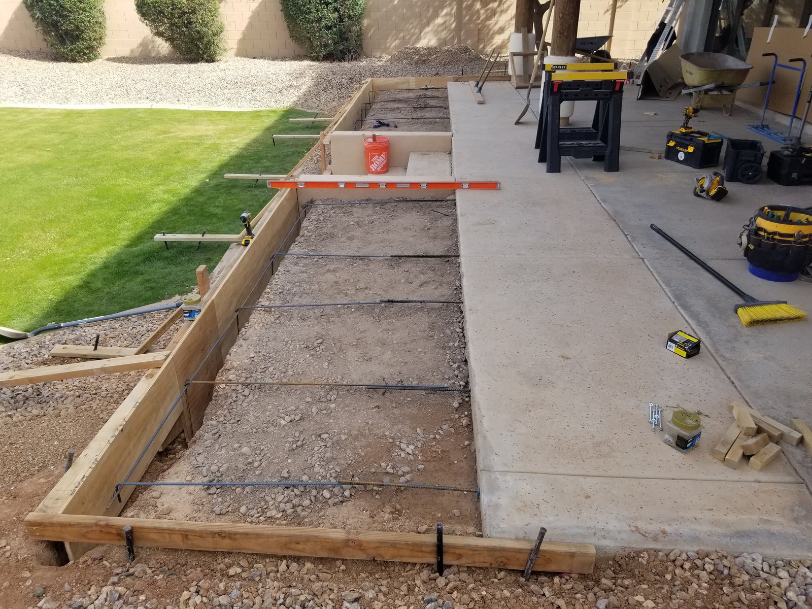 Timber forms and steel reinforcement along the planned raised patio edge