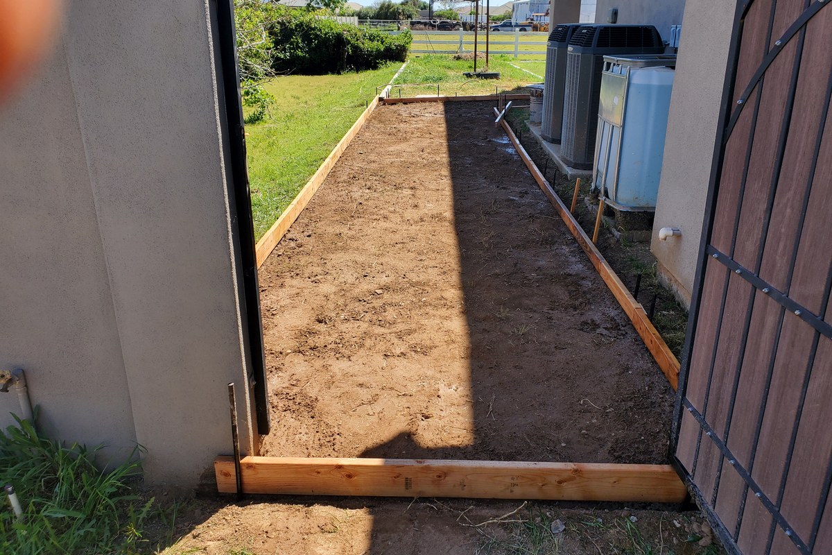Compacted and cleaned base inside the sidewalk formwork before the concrete pour.