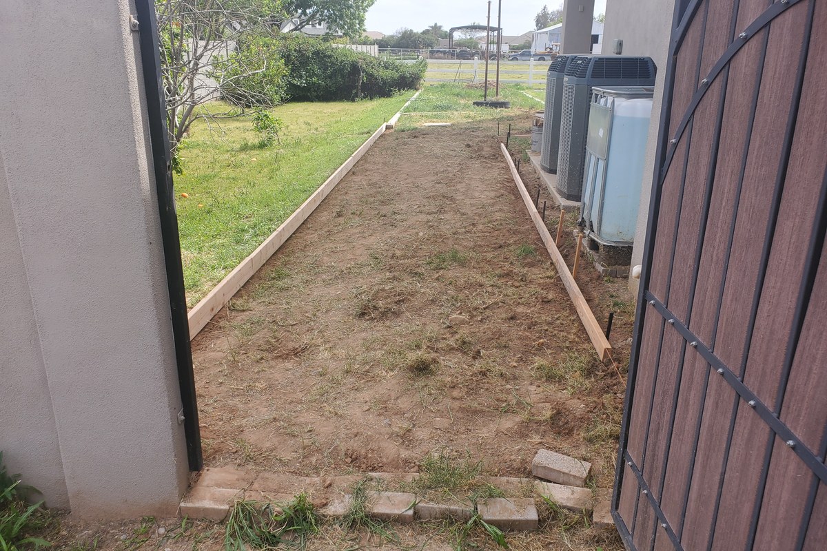 Side-yard sidewalk forms set from the entry side of the home in Gilbert, Arizona.