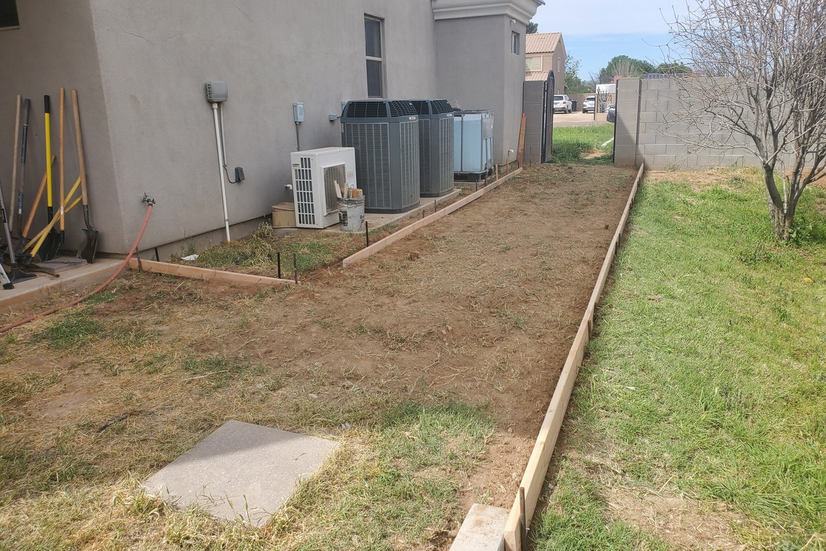 Concrete sidewalk addition forms running along the side yard toward the back gate in Gilbert.