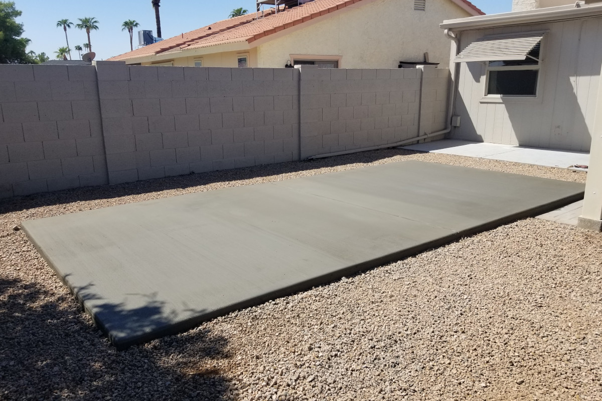 Finished angle view of a backyard concrete slab for a future shed.