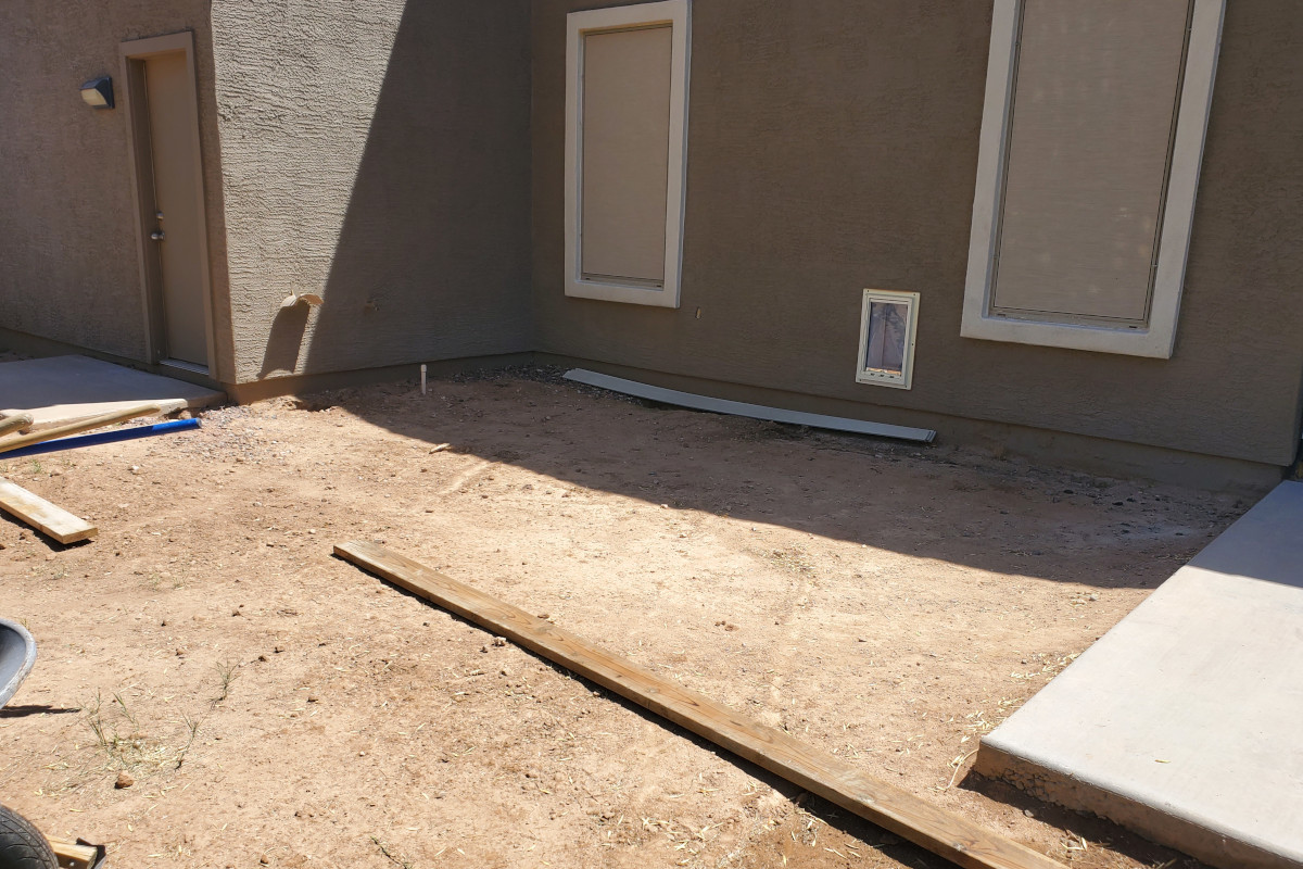 Bare dirt area next to an existing patio before the Gilbert concrete dog pad extension was built.