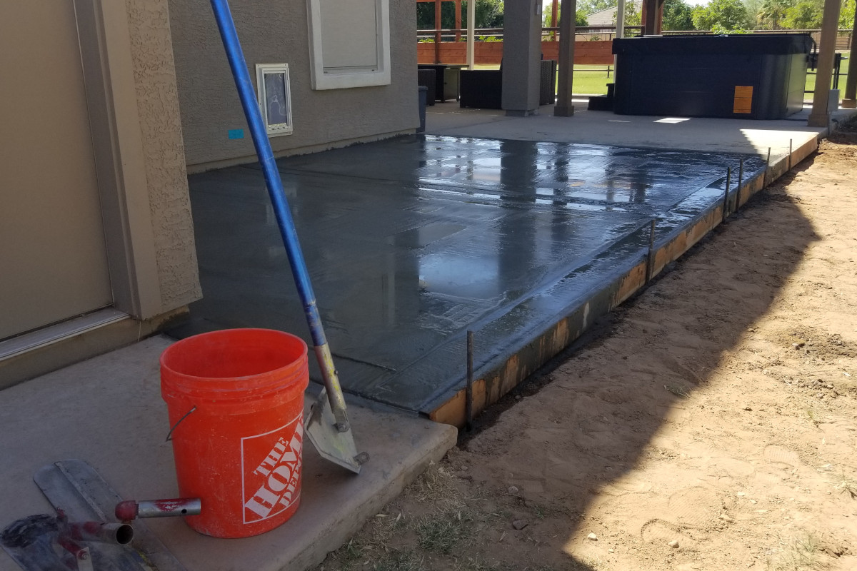 Fresh concrete being placed for a patio extension and dog pad in Gilbert, Arizona.