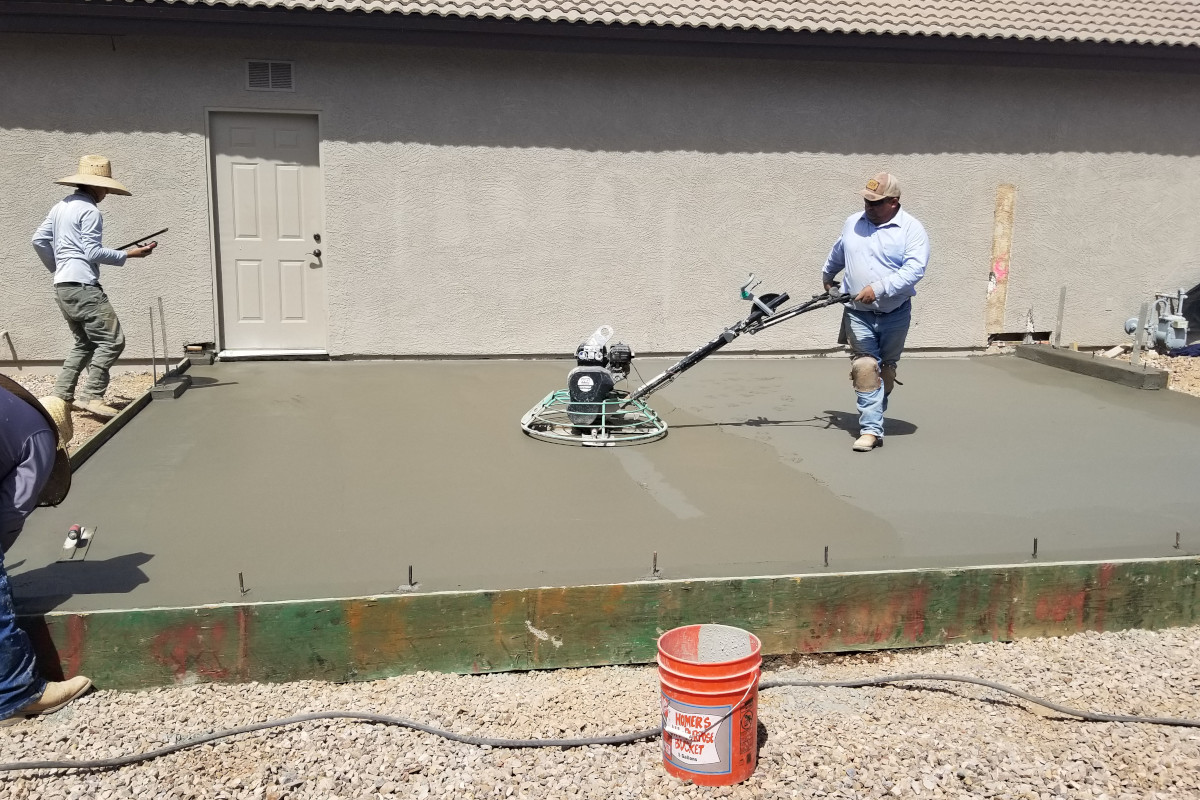 Power trowel finish work on the new garage slab for a home addition project in Gilbert.