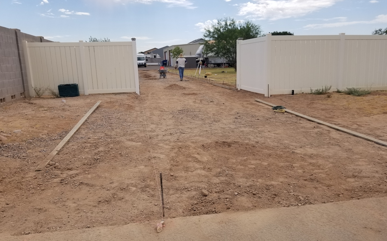 Prepared driveway base and open gates at a Gilbert property