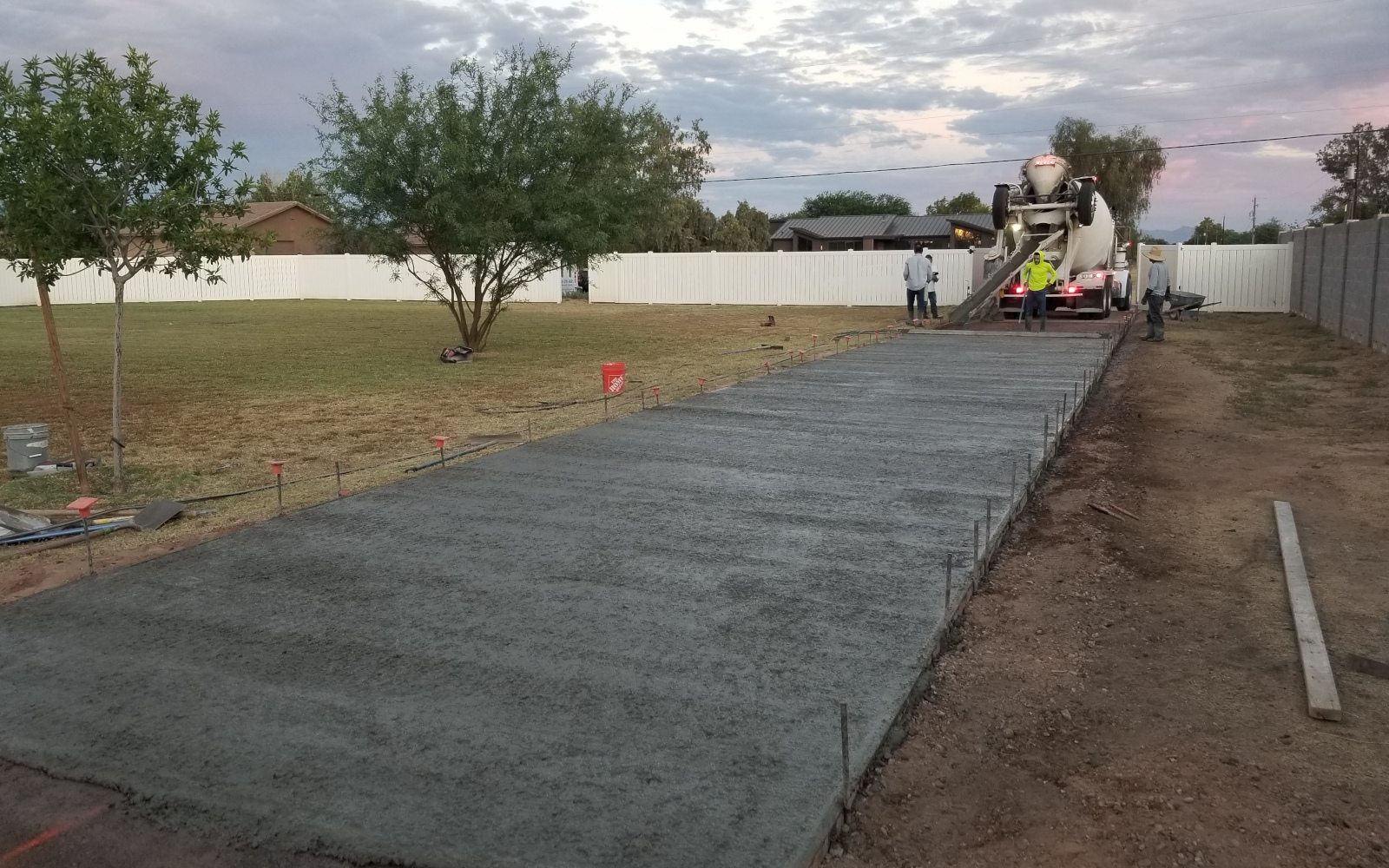 Fresh concrete being placed along a long Gilbert driveway route