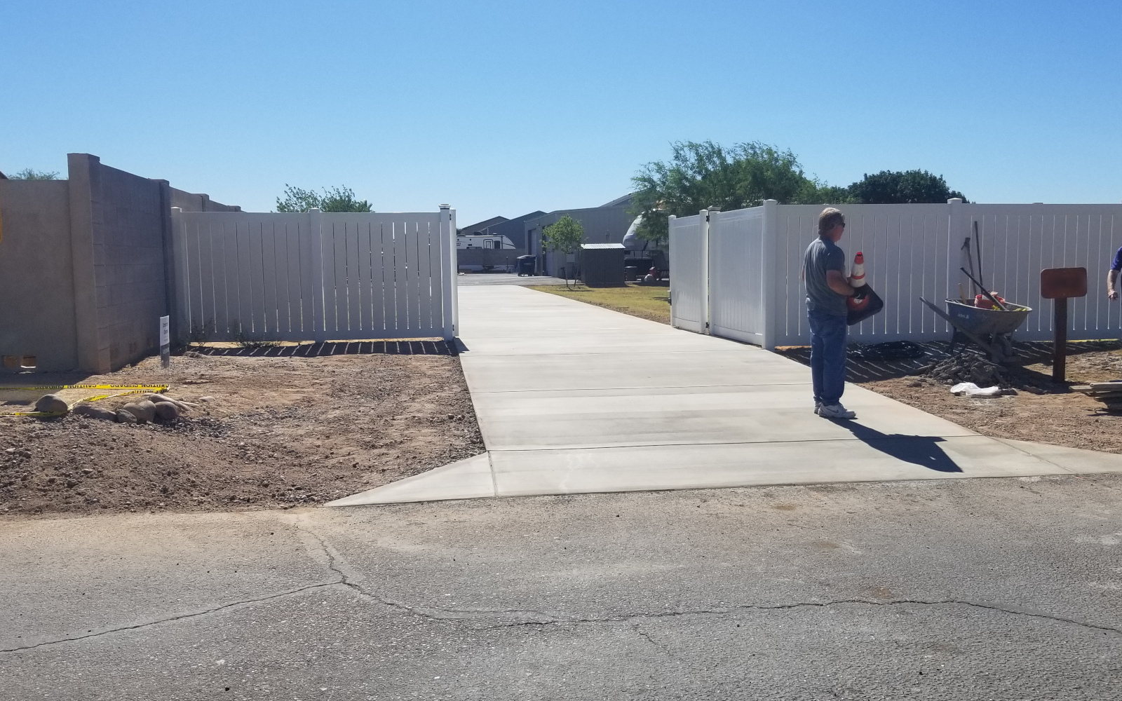 Finished concrete driveway entry through open gates in Gilbert