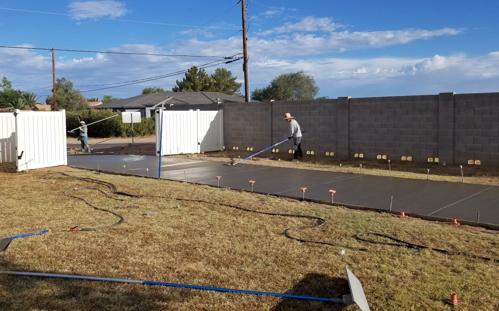 Crew finishing fresh concrete along a Gilbert driveway