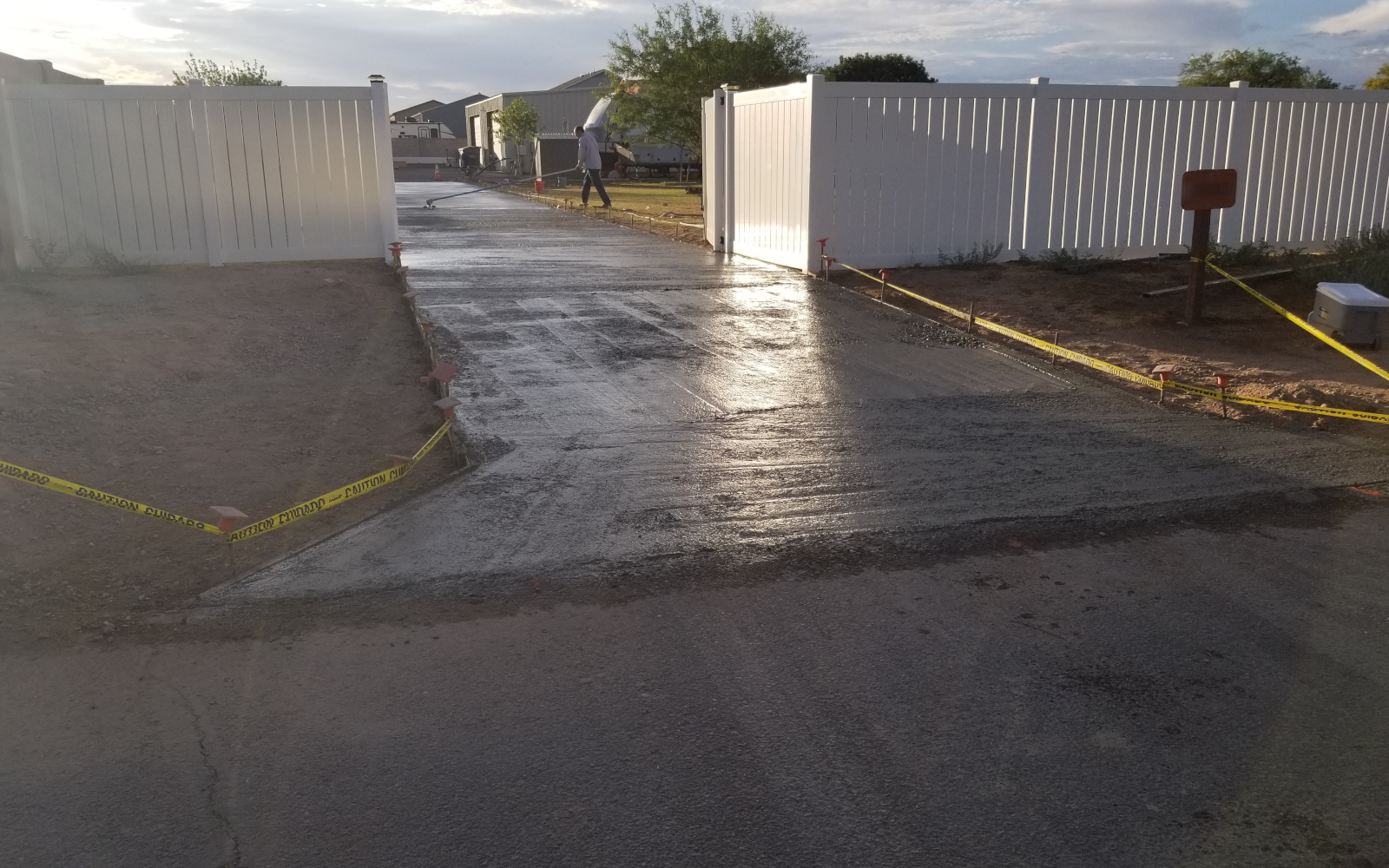 Fresh concrete driveway surface through open gates in Gilbert