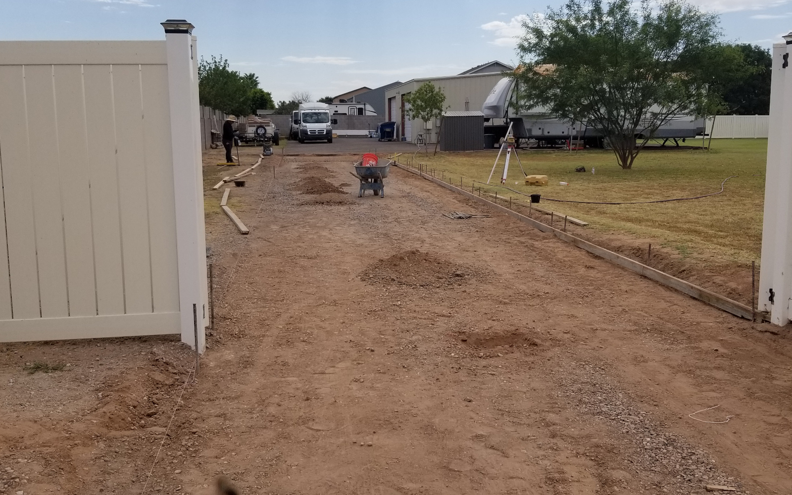 Long driveway route laid out between open gates at a Gilbert property.