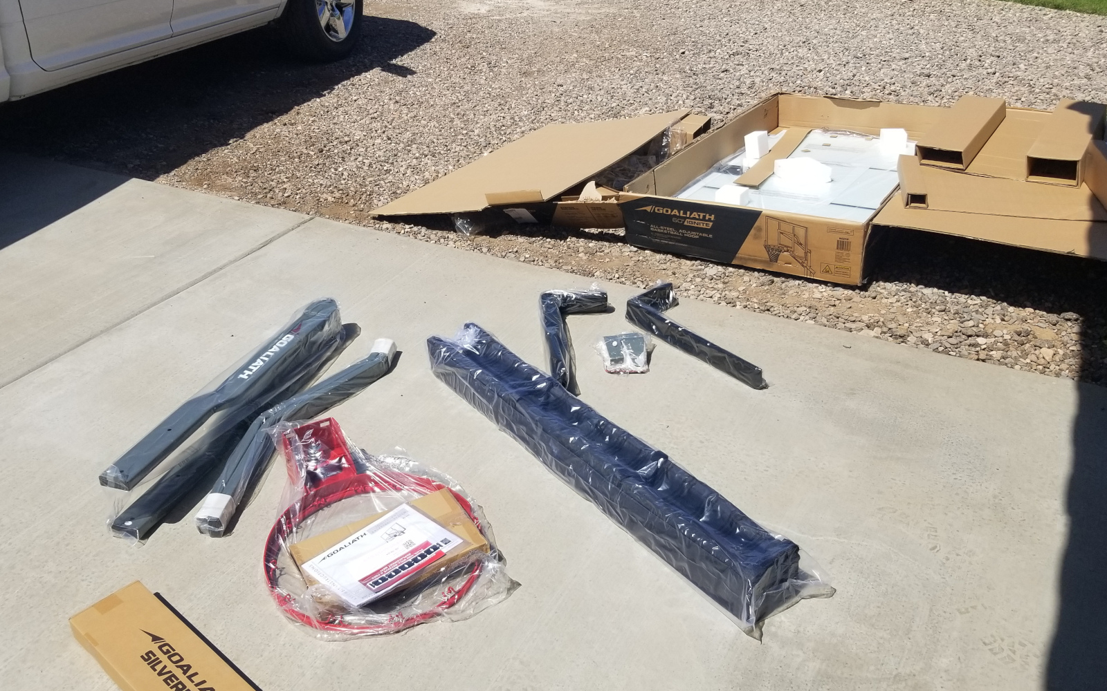 Basketball hoop components laid out on new concrete in Gilbert
