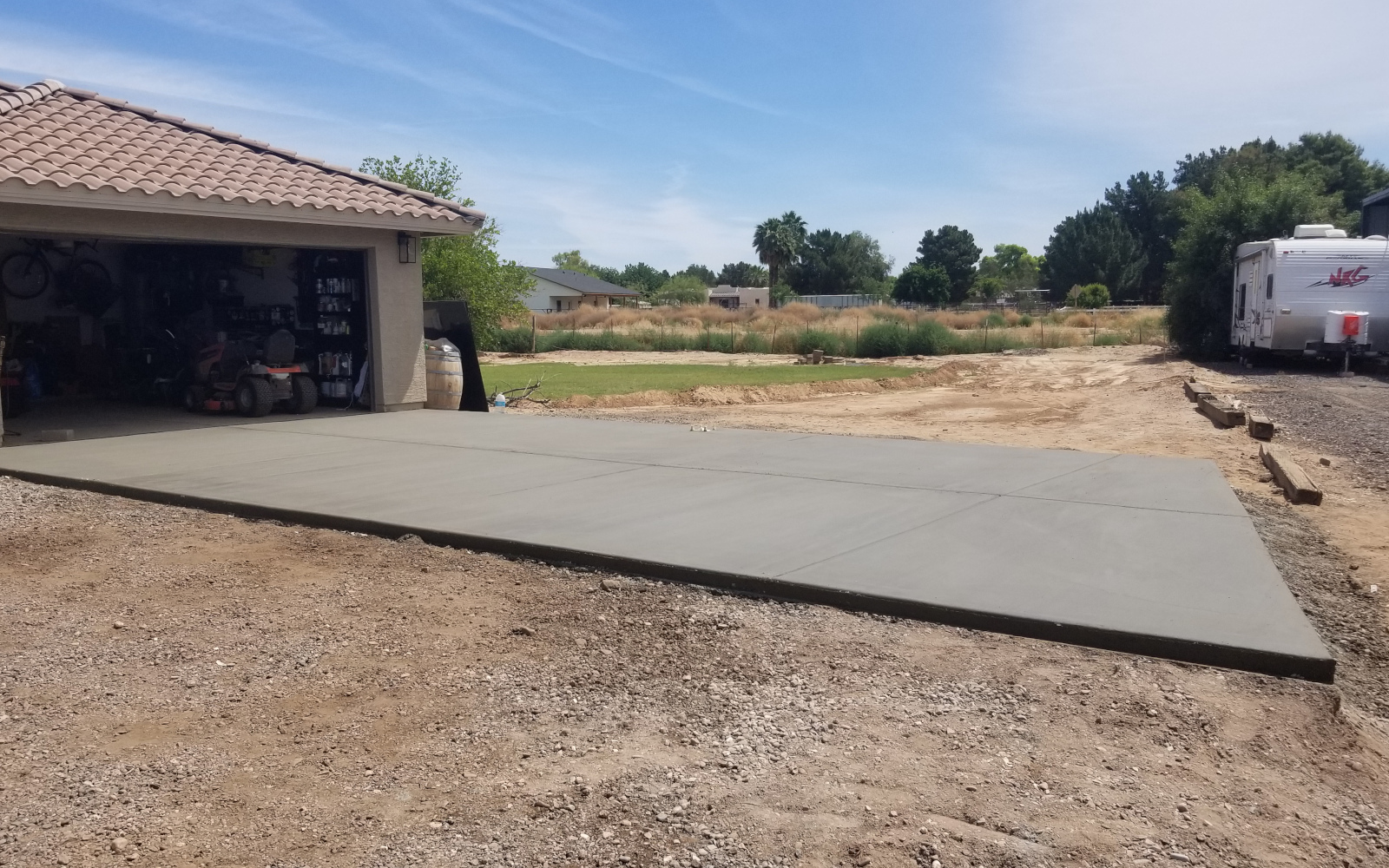 Finished concrete driveway section beside a Gilbert garage