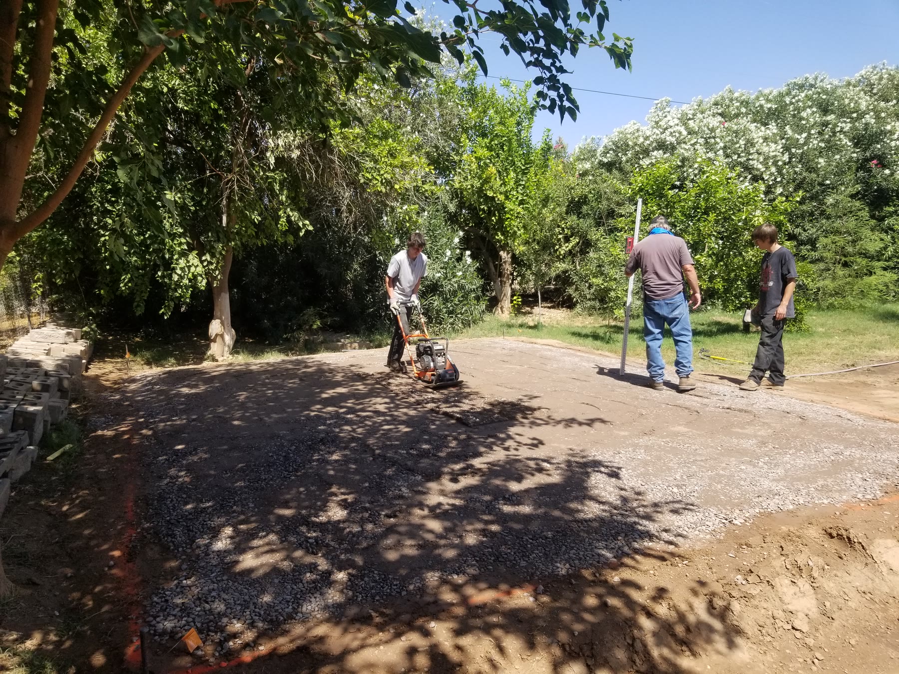 Crew compacting the gravel base at the planned Gilbert shed pad location