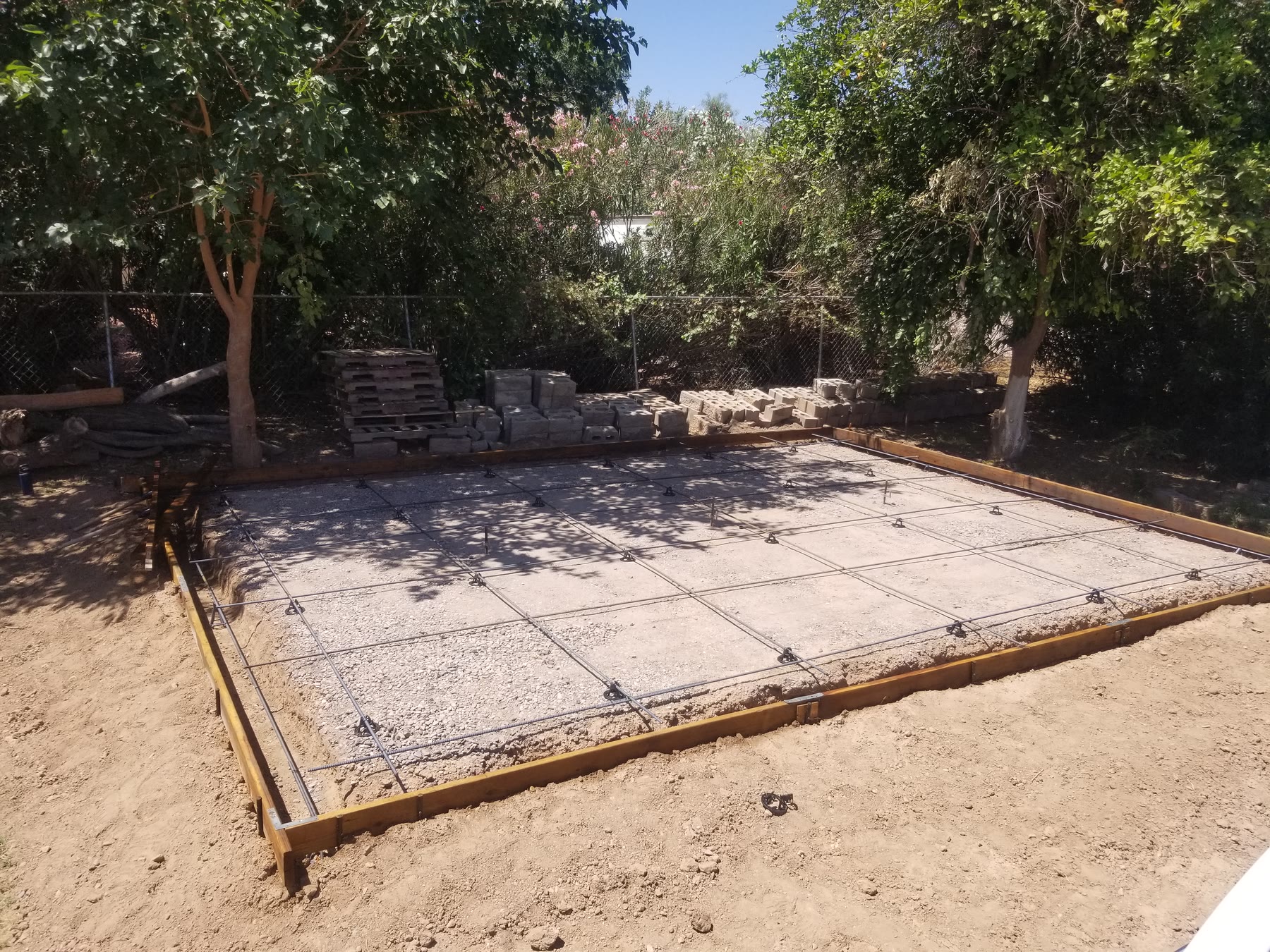 Steel rebar grid installed over a formed gravel base for a Gilbert shed pad