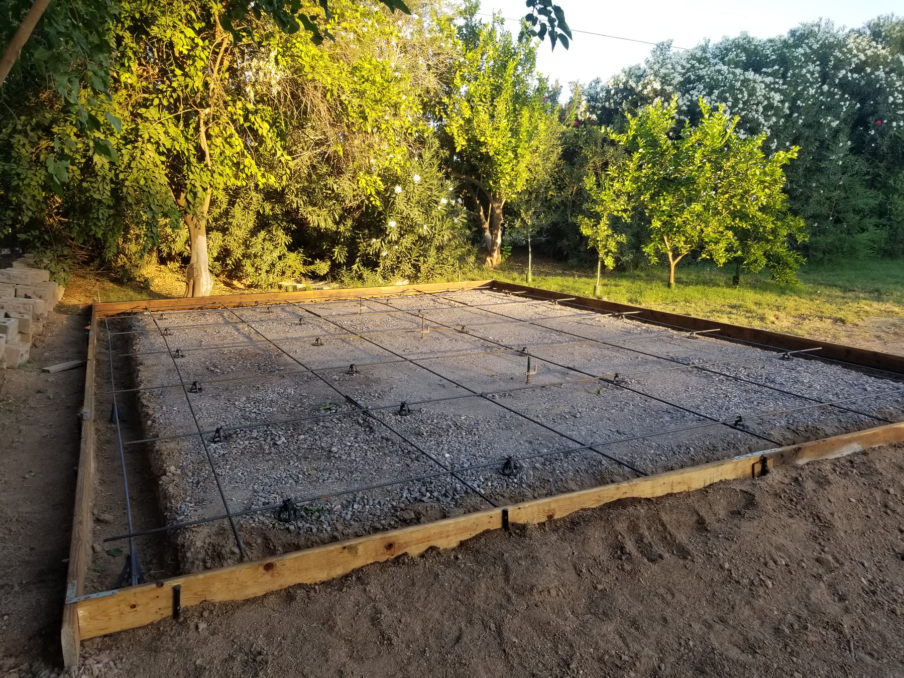Steel reinforcement laid over a formed gravel base for a shed pad in Gilbert, Arizona.