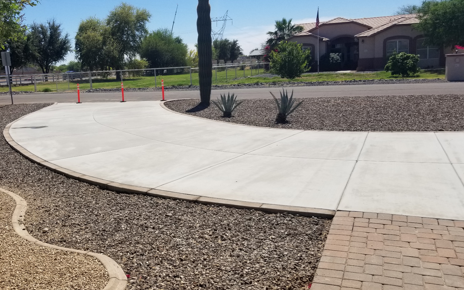 Completed circular concrete driveway curving around landscaped planting at a San Tan Valley home.