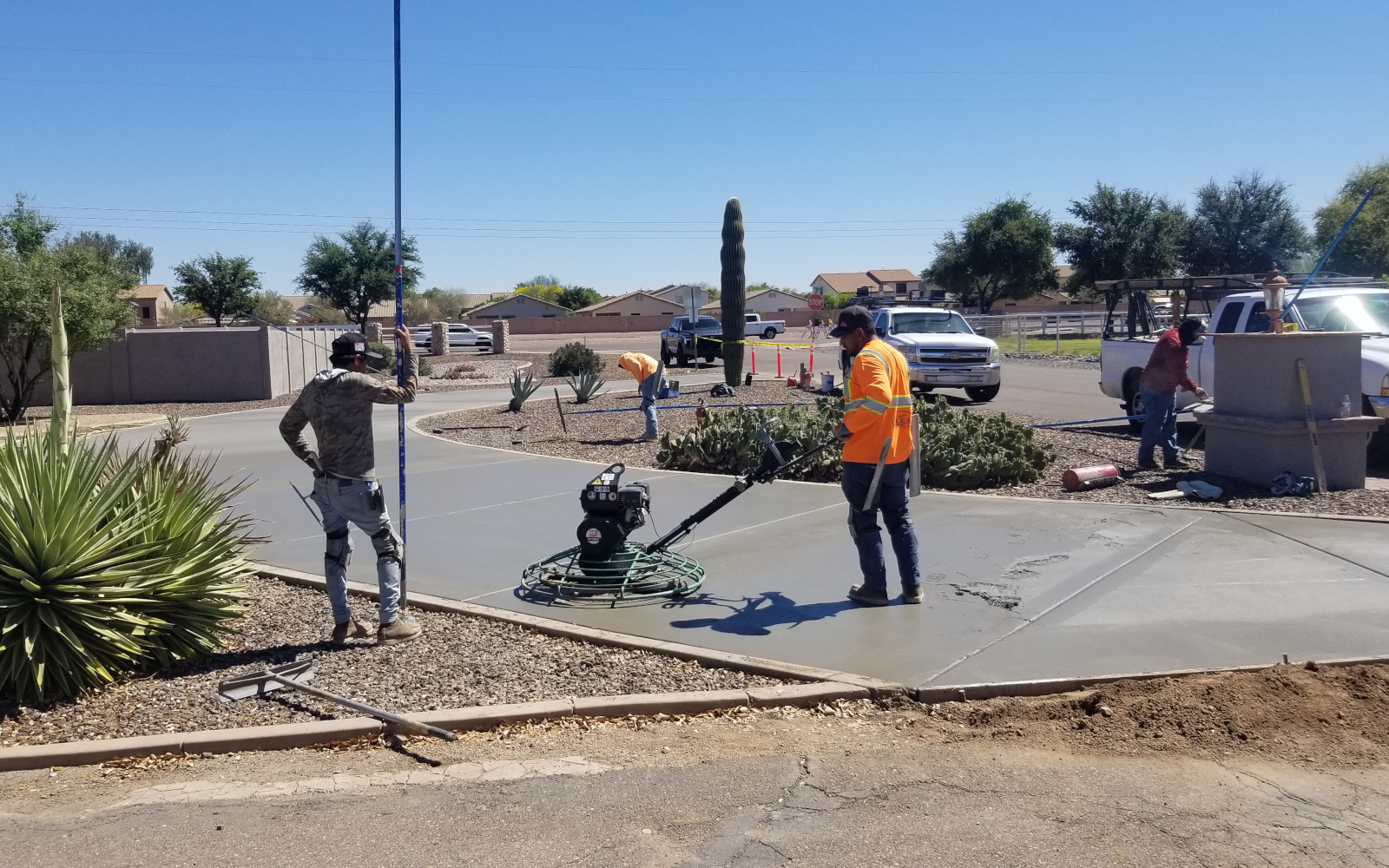 Crew finishing fresh curved driveway concrete in San Tan Valley