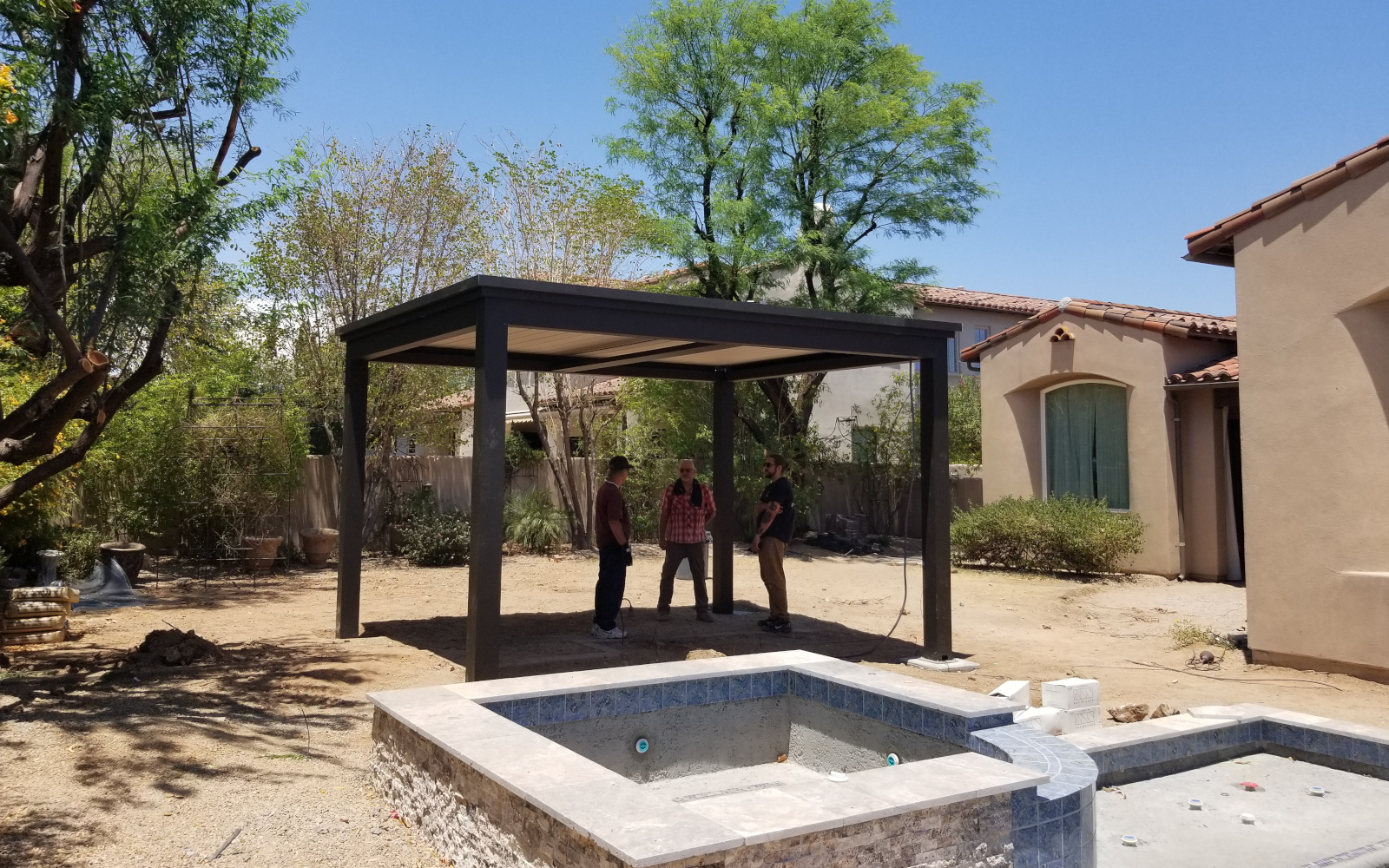 Partially assembled motorized pergola beside a Scottsdale backyard pool