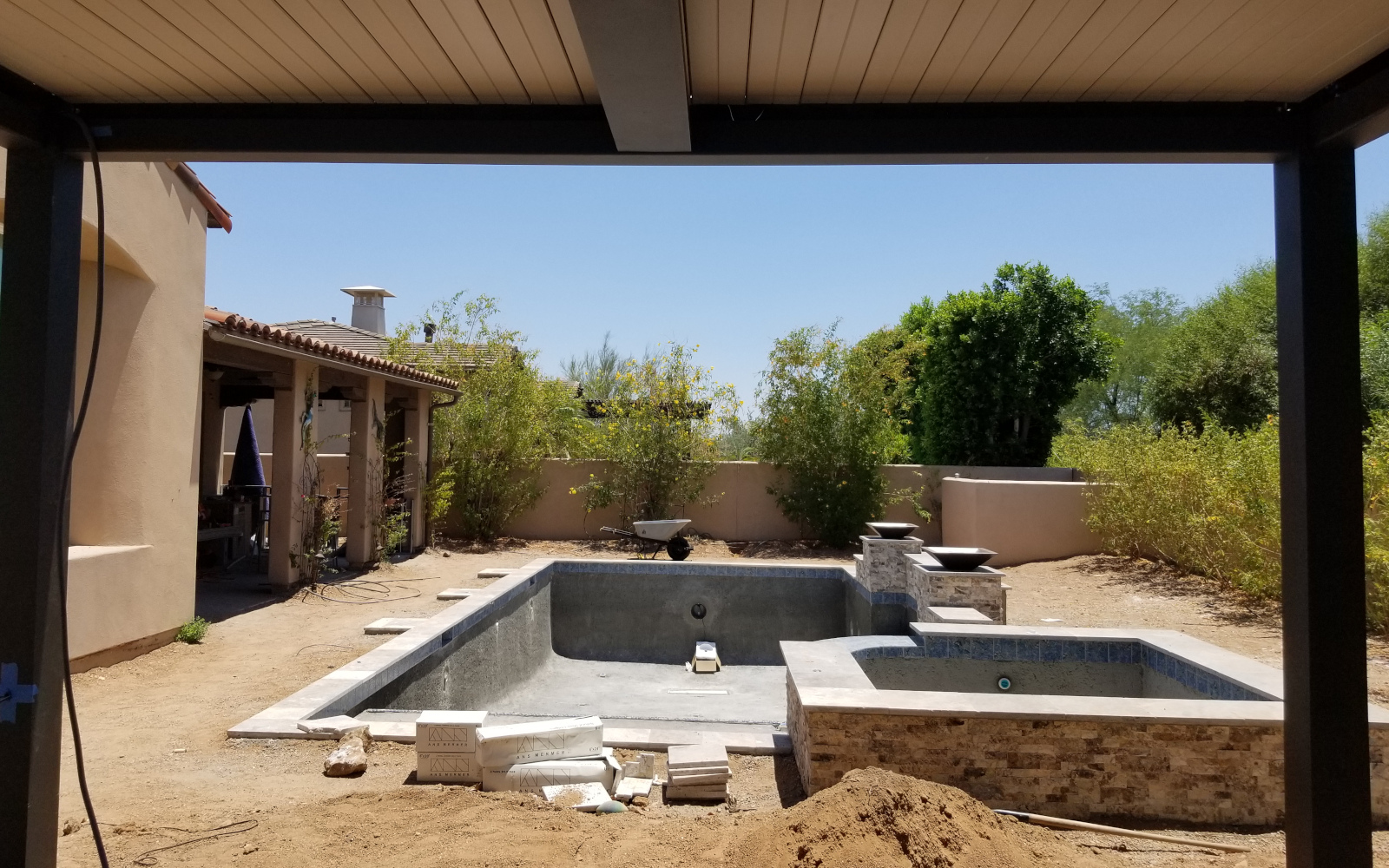 View through a motorized pergola toward a Scottsdale backyard pool