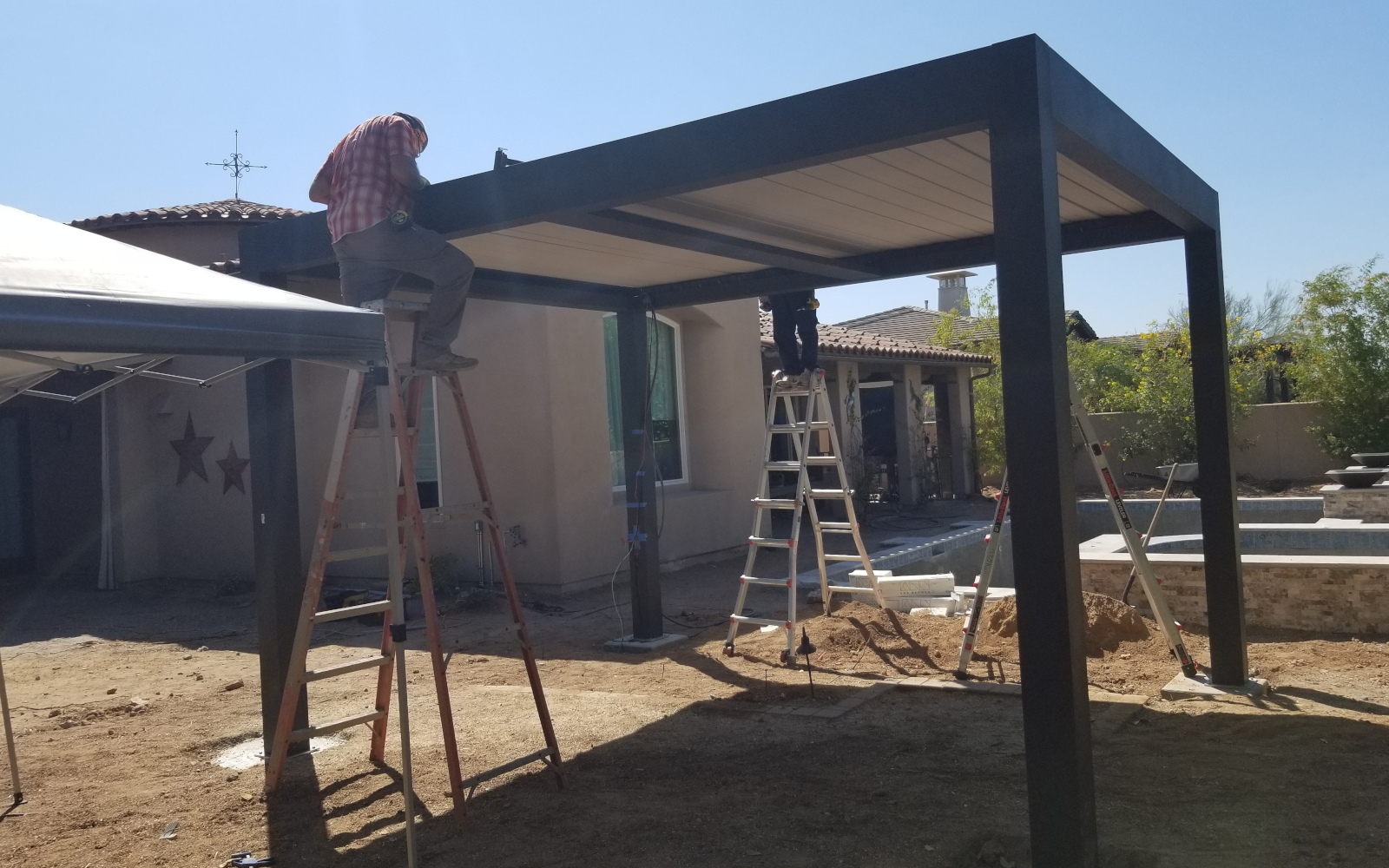 Crew installing the roof of a motorized pergola in Scottsdale