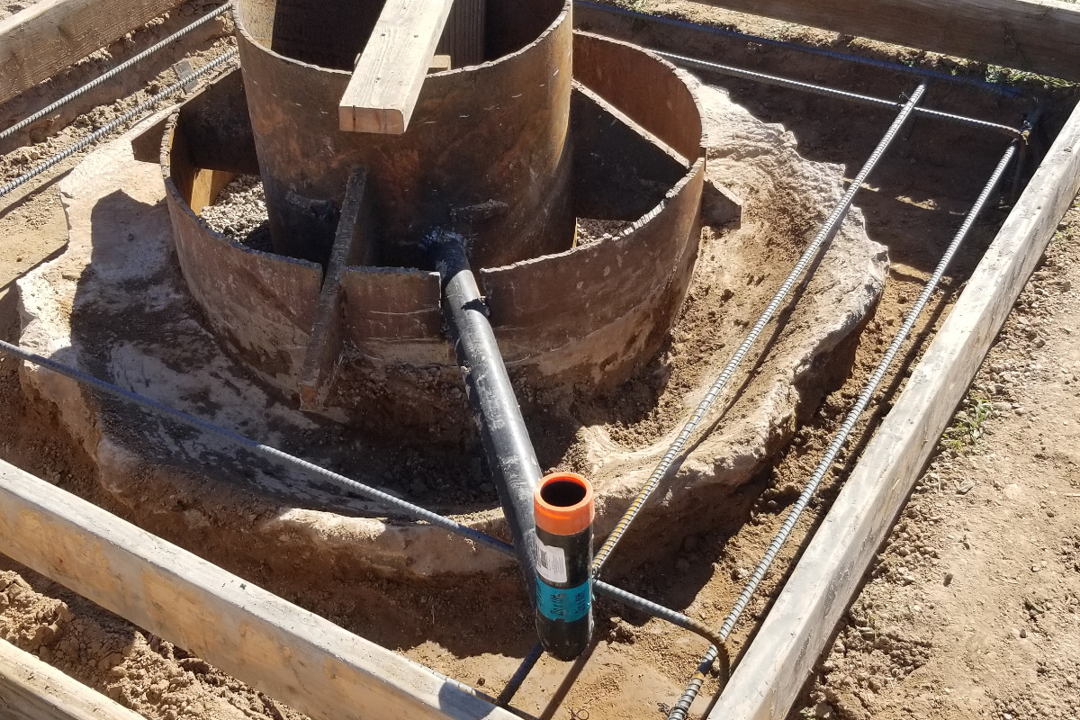 A metal pipe coming out of a well head.