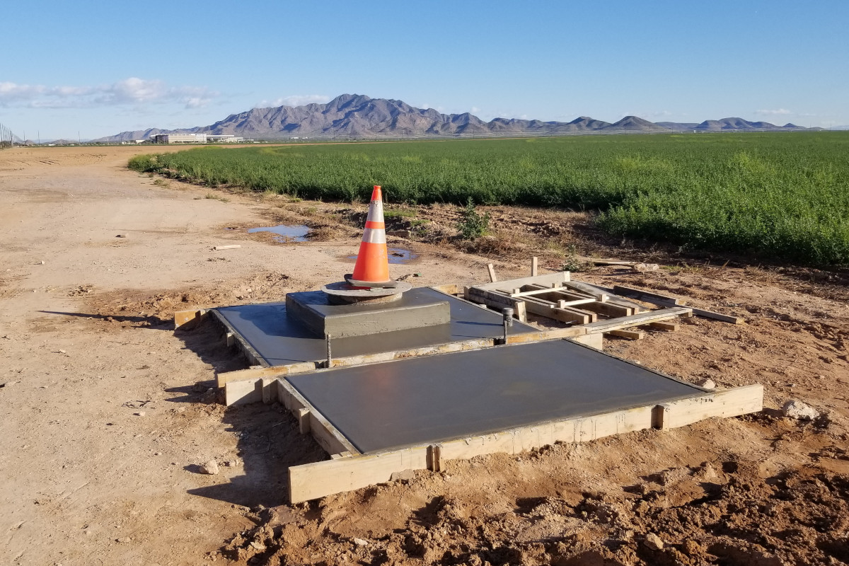 Freshly poured concrete base and pad for a well head in Chandler, Arizona.
