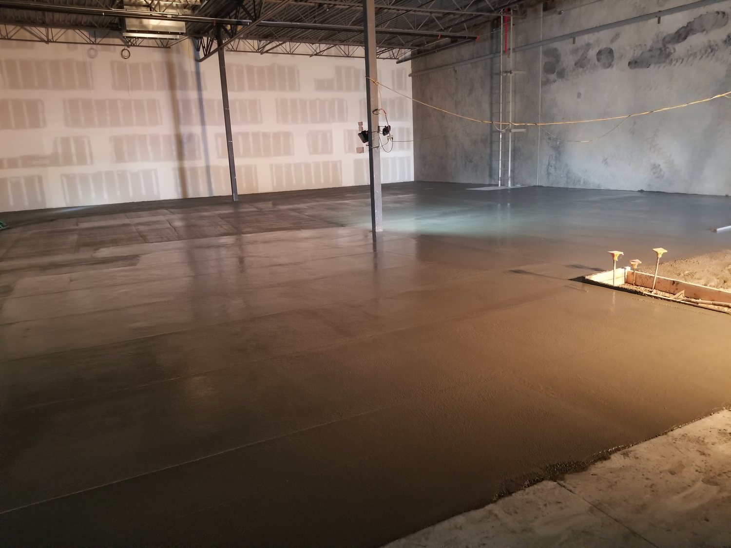Broad concrete floor inside a commercial building under construction